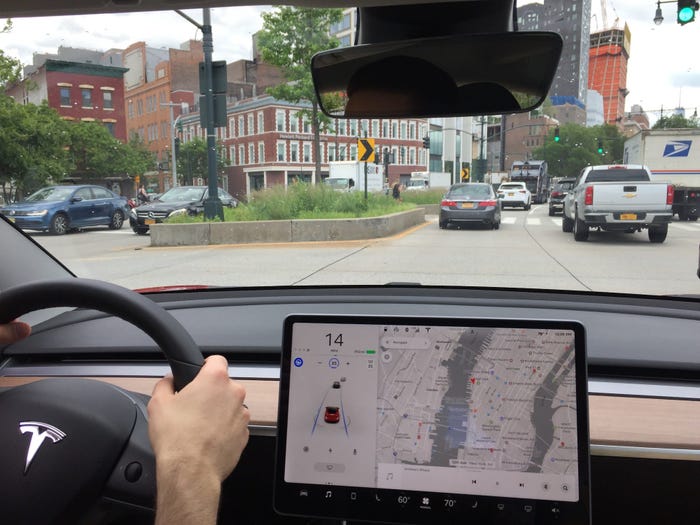 Individual driving through city with Tesla Autopilot engaged