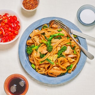 A platter of pad see ew Thai stirfried noodles with chicken and Chinese broccoli.